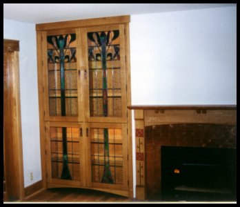 Built-in leaded glass front bookcases flanking Arts &amp; Crafts fireplace 